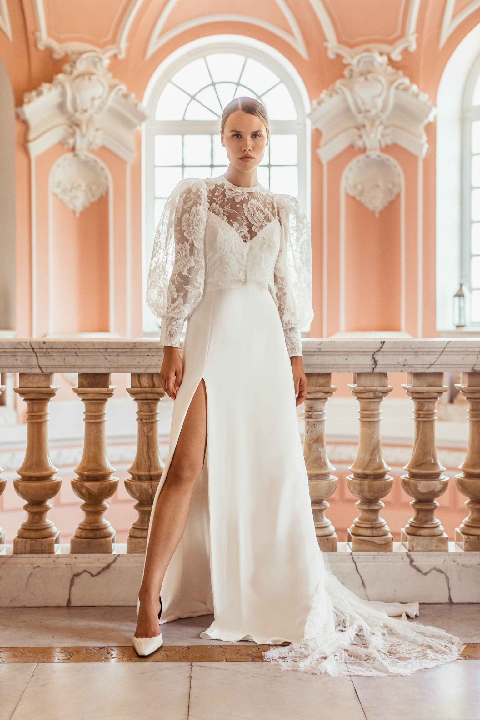 Essayage de la robe de mariée May et de sa cape de mariée Palazzo Caroline Takvorian, modèle princesse moderne avec manches ballon et longue traîne en dentelle, showroom Paris.